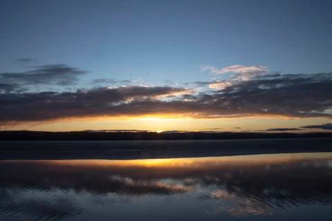 Sunset sky on the lake with clouds Stock Photos
