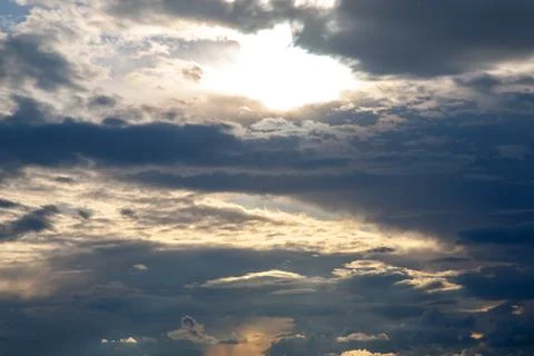 Sunset sky with layered clouds in various shades of blue, gray, and gold. A.. Stock Photos