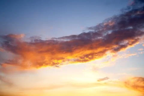 Sunset sky with layered clouds in various shades of blue, gray, and gold. A.. Stock Photos