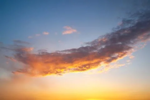 Sunset sky with layered clouds in various shades of blue, gray, and gold. A.. Stock Photos