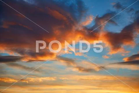 Sunset sky orange clouds over blue Stock Photos