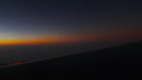 Sunset sky orange horizon viewed from airplane window at high altitude Stock Footage 343313896