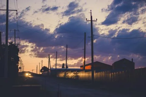 Sunset sky over the empty outskirts. View of the country street at dusk. Tinted Stock Photos