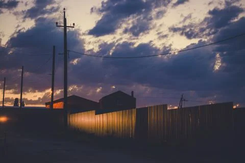 Sunset sky over the empty outskirts. View of the country street at dusk. Tinted Stock Photos
