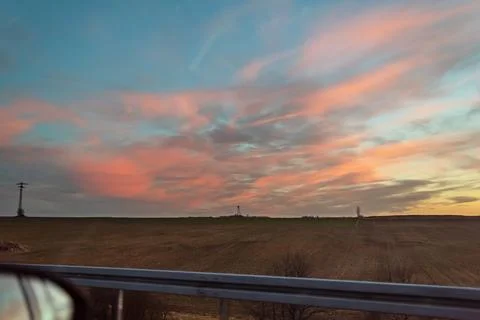 Sunset sky over the field, power line, photos from the car Stock Photos