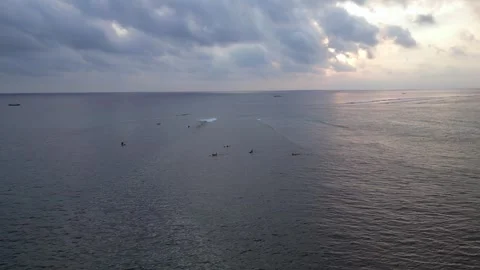 Sunset sky over ocean with surfers and cloudy weather. Magic aerial view drone Stock Footage 335150823