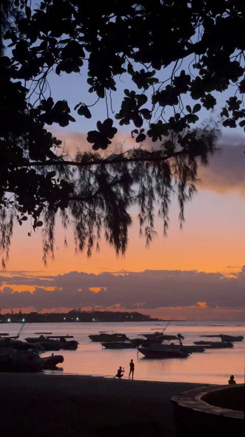 Sunset sky over the sandy Troux aux Biches beach with a modern motor boats Stock Footage 230250371