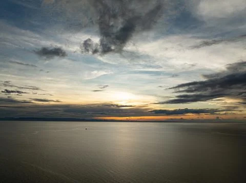 Sunset sky over tranquil sea with soft clouds. Camotes, Philippines. Stock Photos