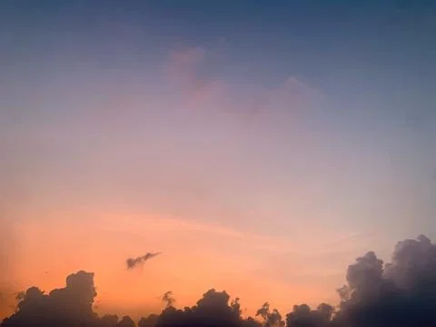 Sunset Sky with Pink Orange Gradient and Dark Clouds Silhouette Stock Photos