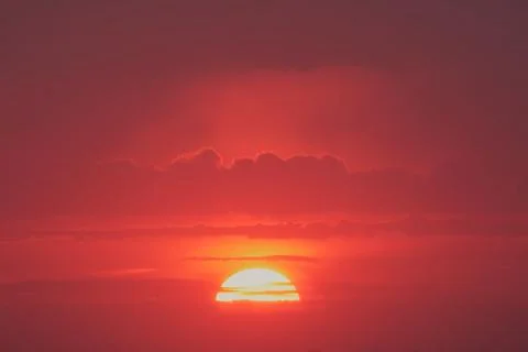 Sunset sky with red light of the setting sun. Evening clouds in the orange .. Stock Photos