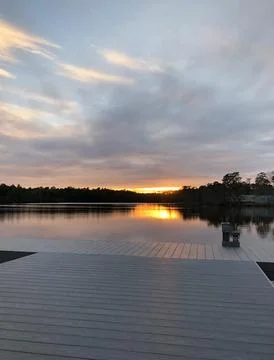 Sunset sky is reflected in the lake, forest and river landscape Stock Photos