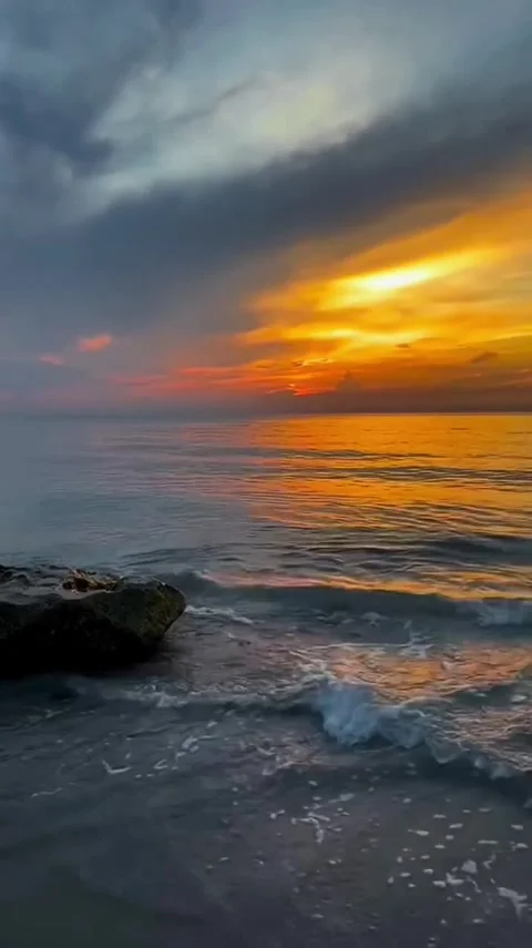 Sunset Sky Reflecting on Incoming Ocean Waves Video stock 343557511