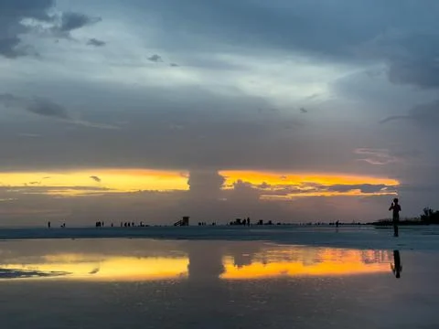 Sunset Sky Reflection and Silhouetted Figure on Florida Beach Fotos Stock