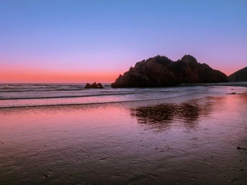 Sunset sky reflections on the beach at Pacific Coast Stock Photos