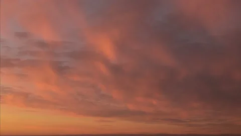 Sunset sky with soft, fluffy, blurred pastel colored clouds moving on pink, oran Stock-Footage 164993351
