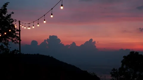 Sunset sky with string lights over ocean view Stock Footage 303395173