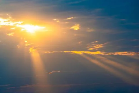 Sunset sky with sun rays through clouds Fotos Stock