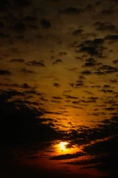 Sunset Sky with Sun Shining Through Clouds Stock Photos