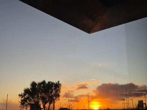 Sunset sky with trees and open window framing Stock Photos