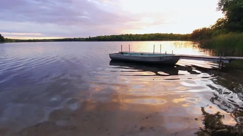 Sunset small boat at dock ripple reflections Video stock 187748132