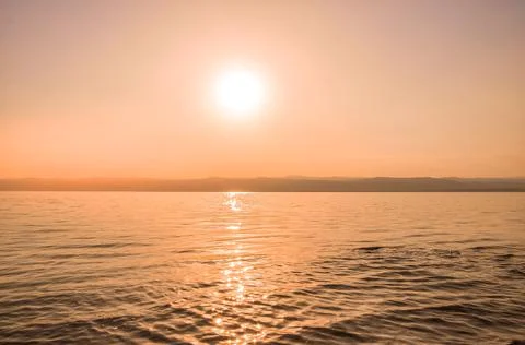 Sunset with small sea waves at the dead sea at sunset Stock Photos