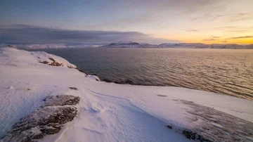 Sunset on the snow-covered shore of the Barents Sea Stock Footage 85749709