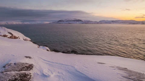 Sunset on the snow-covered shore of the Barents Sea Stock Footage 97300401