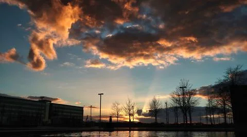 Sunset with spectacular clouds over water in the city Stock Photos