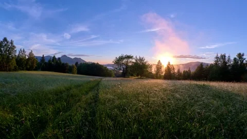 Sunset in the spring Carpathian landscape, the sun's rays illuminate a green 動画素材 301647992