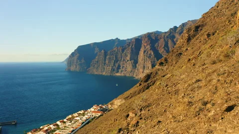 Sunset steep Los Gigantes cliifs rocky barren volcanic mountains with dark blue Video stock 226475492