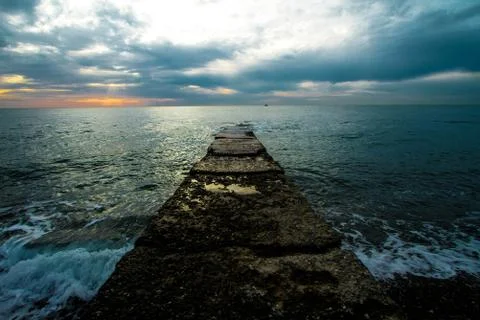 Sunset on a stone pier. Stock Photos