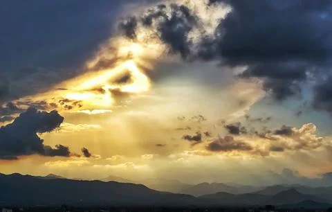 Sunset with storm clouds over mountains Stock Photos