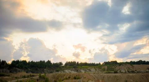Sunset with storm clouds over a quarry and forest in summer Stock Photos
