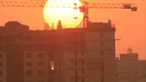 Sunset sun disappear behind building with tower crane Video stock 161632013