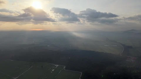 Sunset sun glows through clouds above fields Vidéo 337547203