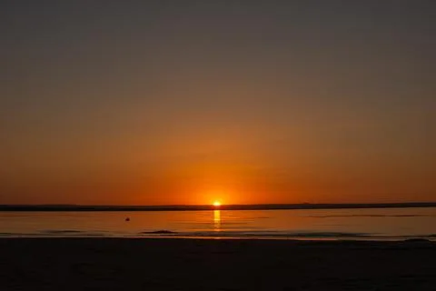Sunset sun going down the horizon Stock Photos