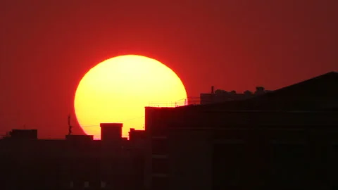 Sunset sun move down behind town building Stock Footage 149194084