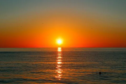 Sunset sun over the sea with reflection in the water Stock Photos