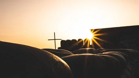 Sunset sun rays cross stone wall golden silhouettes Stock Photos