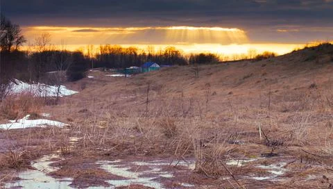 Sunset with sun rays in hilly area. the sun's rays illuminate the hilly meado Stock Photos