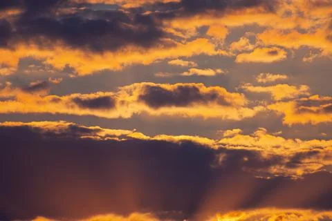 Sunset sun rays radiating behind low cloud layer on horizon 스톡 사진