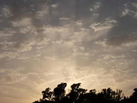Sunset sun with a set of altocumulus clouds in the sky Stock Photos
