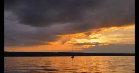 Sunset, sun shines through dark clouds over Lake Ammersee Stock-Footage 277868128