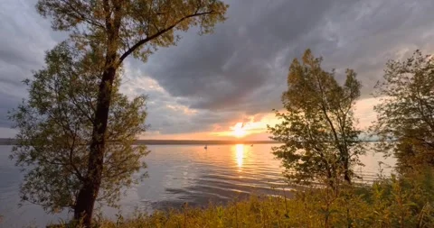 Sunset, sun shines through dark clouds over Lake Ammersee Stock Footage 277868197