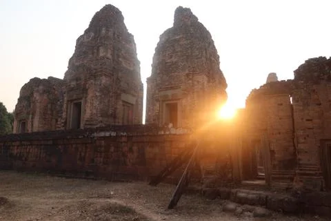 Sunset, sun shining through old angkor wat tower ruins of khmer empire, tourism Stock Photos