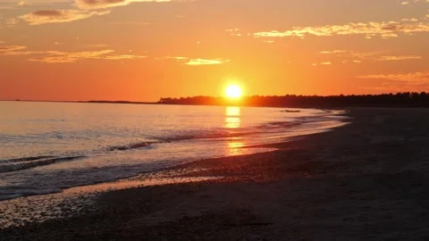 Sunset with sun still visible over the horizon on a beach Stock Footage 166373163