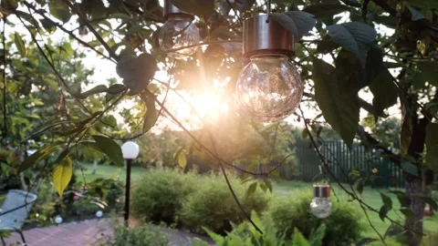 Sunset sun through decorative lanterns in the garden Stock Footage 153084754