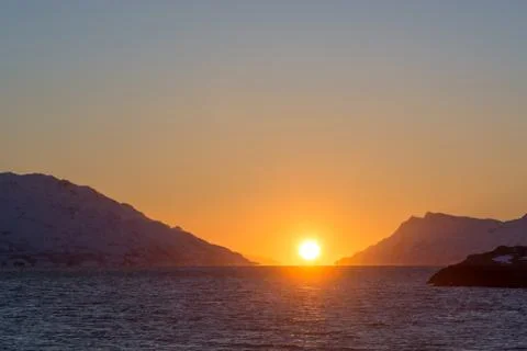 Sunset, sun touching ocean Stock Photos