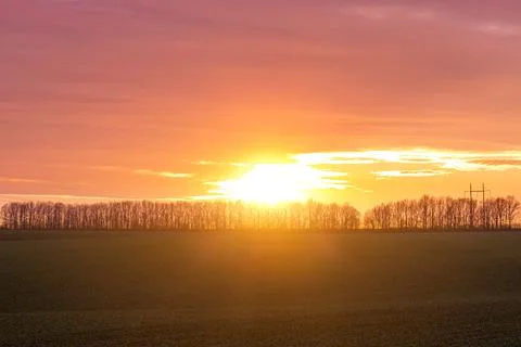 Sunset, sunbeams shining through the trees in the distance, autumn landscape Stock Photos