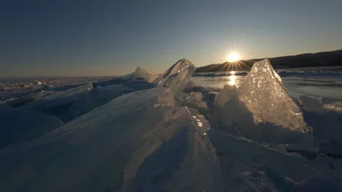 Sunset with sunlight trough transparent piece of ice floe Stock Footage 177770725